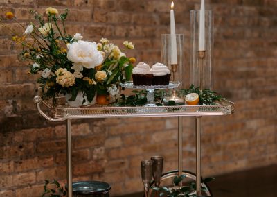 An ornate tray on wheels with wedding decorations and cakes.